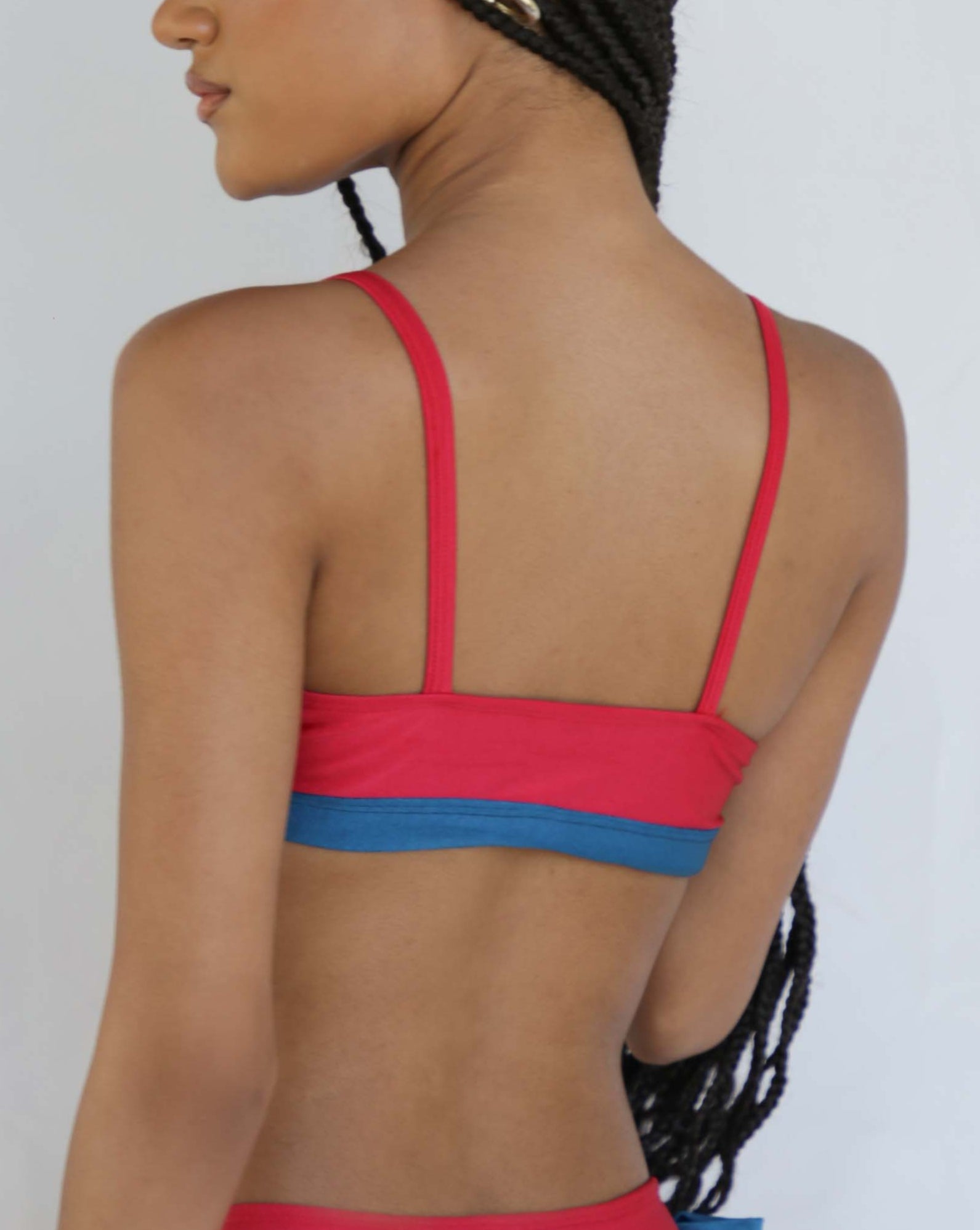Woman wearing a red and blue bikini against a white background