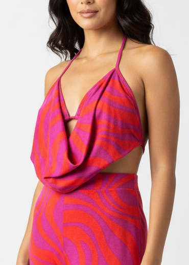 Woman wearing a pink and purple patterned cowl neck top.